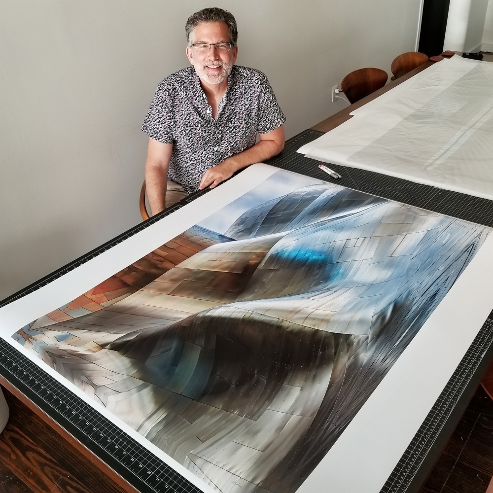 Photographer Andrew Prokos seen with a large-scale fine art print from his architectural series 'Gehry's Children'