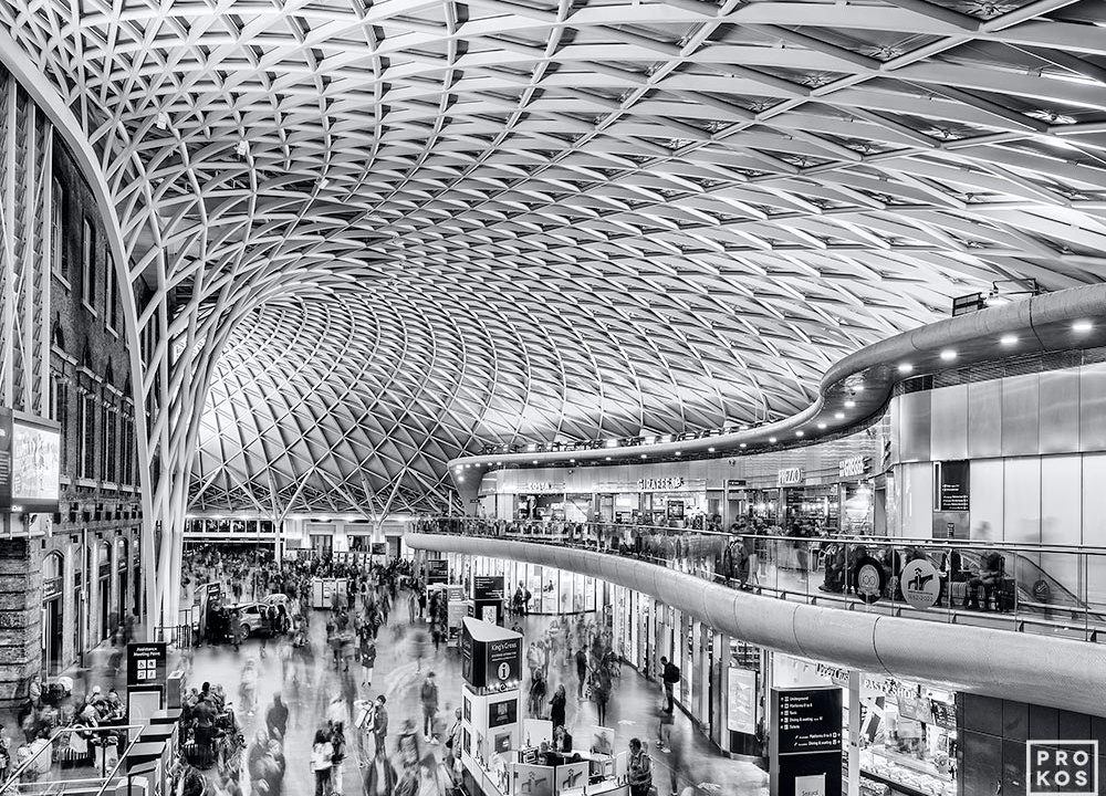 A black and white photograph of the interior of King's Cross Station in London, United Kingdom at rush hour. Limited edition fine art prints of this photo are available up to 80 inches in width and framed in various wood, metal, and acrylic styles. 