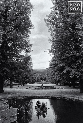 A black and white view of a water nymph statue emerging from a pool in the gardens at La Granja de San Ildefonso, Spain