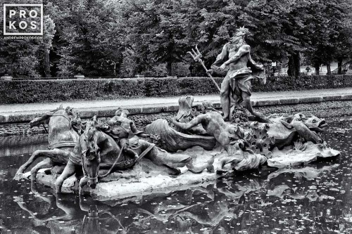 A photo of the statue of Neptune with horse chariot in the gardens at La Granja de San Ildefonso, Spain in black and white. Framed fine art prints of this photo are available in various sizes.