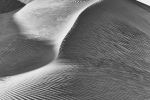 A black and white landscape photograph of a high dune from Liwa desert in the Empty Quarter, Abu Dhabi, United Arab Emirates. Large-format limited edition prints of this photo are available up to 72 inches.
