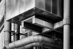 A black and white close-up architectural photo of the exposed pipes, ducts, shafts and stairwells of the iconic Lloyd's Building in London, by architect Richard Rogers. Limited edition black and white prints of this photo are available up to 72 inches in width and framed in wood, metal, acrylic