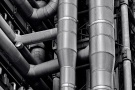 A black and white close-up architectural photo of the exposed stainless steel pipes and ducts of the iconic Lloyd's Building in London, by architect Richard Rogers. Limited edition black and white prints of this photo are available up to 72 inches in width and framed in wood, metal, acrylic