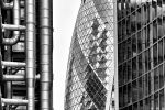 A black and white view of the contrasting facades of towers in the City of London, including 30 St. Mary Axe (the Gherkin), the Lloyd's building, and Willis Towers. High-definition fine art prints of this photograph are available up to 72 inches in height.
