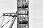 A black and white close-up view of the London Eye ferris wheel, United Kingdom. The wheel, pods, and visitors inside are captured in detail with a high-key rendition. Limited edition prints of this photo are available up to 80 inches in height.