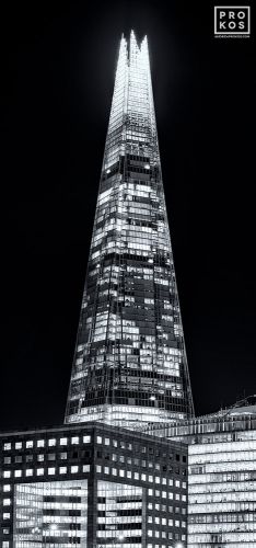 A black and white vertical panoramic photo of London's Shard captured at night by photographer Andrew Prokos. High-definition fine art prints of this photo are available up to 96 inches in height and framed in various wood, metal, and acrylic styles.