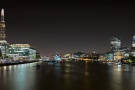 A sweeping panoramic skyline of London, England at night, including the skyscrapers of the City of London, The Shard, City Hall and the Tower of London