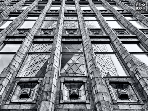 Black and white architectural photography of the Art Deco era Holland House Building with the adjacent Gherkin tower reflected on the facade, London, United Kingdom. Fine art prints of this photo are available up to 72 inches in width and framed in various wood, metal and acrylic styles.
