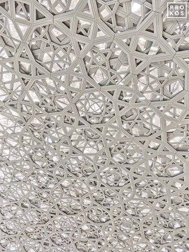 An ultra high-definition photo of the intricate geometric patterns found in the dome interior at the Louvre Museum by architect Jean Nouvel, in Abu Dhabi, United Arab Emirates.