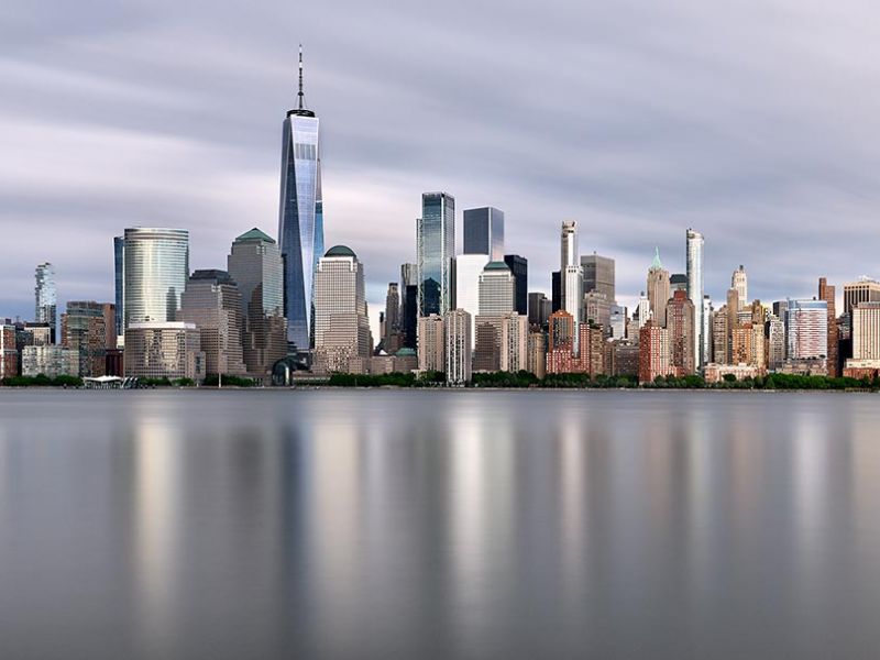 New York skyline photo of Lower Manhattan and the World Trade Center during the day. Captured with an eight minute long-exposure time by photographer Andrew Prokos