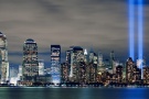 A large-format panoramic skyline of Lower Manhattan at night with the Towers of Light commemorating 9/11