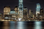 A long-exposure cityscape photo of Lower Manhattan, Hudson River, and the World Trade Center at night