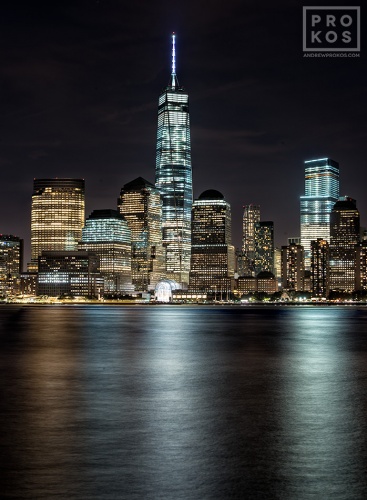 A long-exposure cityscape photo of Lower Manhattan, Hudson River, and the World Trade Center at night