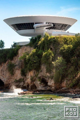A view of the Niteroi Contemporary Art Museum (Museu de Arte Contemporanea) by architect Oscar Niemeyer as seen in situ from a distance. Fine art prints of this photo are available framed in various styles.