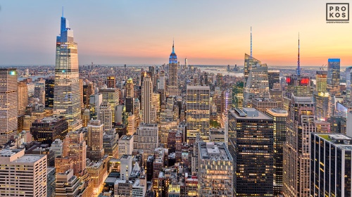 A high-definition cityscape capturing a wide angle view of Midtown Manhattan and the Empire State Building as seen from Rockefeller Center at dusk, New York City. Also shown are One Vanderbilt and the Bank of America building building. Large-format fine art prints of this photo available up to 120"