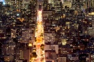 A vertical cityscape photograph of New York City at night as seen from SoHo
