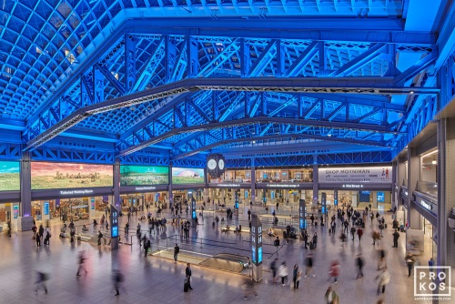 An elevated interior view of Moynihan Train Hall / Farley Building in Manhattan, New York City as seen at night. Captured by architectural photographer Andrew Prokos for Vornado Realty Trust. The renovation architect is Skidmore, Owings & Merrill (SOM). Fine art prints are available framed in various styles.