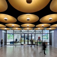 A long-exposure interior view of the retail concourse and Meta office lobby at Moynihan Train Hall, Penn Station in Manhattan, New York City. Captured by architectural photographer Andrew Prokos
