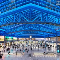 An elevated architectural interior of Moynihan Train Hall / Farley Building in Manhattan, New York City as seen at night. Captured by architectural photographer Andrew Prokos for Vornado Realty Trust. The renovation architect is Skidmore, Owings & Merrill (SOM). Fine art prints are available framed in wood, metal and acrylic styles.