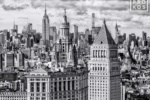 A black and white photograph of the Municipal Building, 40 Centre Street, and the skyscrapers of Midtown Manhattan and the Empire State Building in the distance, New York City.