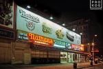 A street scene photo of Nathan's Famous restaurant at night in Coney Island, Brooklyn
