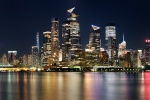 A panoramic skyline of New York City, Hudson Yards, and the Empire State Building at night as seen from Hoboken, NJ