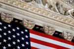 An architectural detail photo from the facade of the New York Stock Exchange (NYSE) facade draped in an American flag