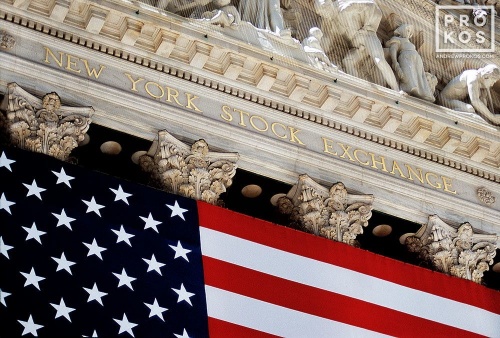 An architectural detail photo from the facade of the New York Stock Exchange (NYSE) facade draped in an American flag