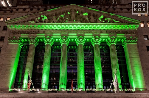 A fine art architectural photo of the illuminated facade of the New York Stock Exchange (NYSE) at night