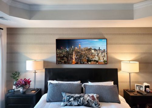 A 60 inch framed limited edition print of 'Night & Day - Manhattan Cityscape #1' by photographer Andrew Prokos on display in a collector's upscale home