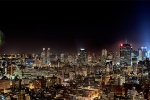 A panoramic long-exposure cityscape photo of the New York City skyline at night with fireworks on the Fourth of July