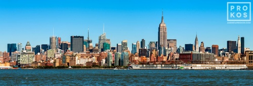 A panoramic skyline photo of New York City and the Hudson River as seen from New Jersey during the day.