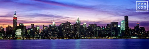A panoramic skyline photo of New York City, the Empire State Building, and the Chrysler Building from Brooklyn at dusk