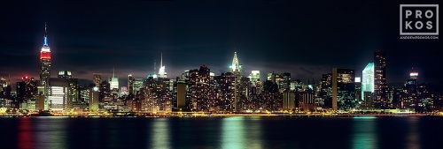 A long-exposure panoramic photo of the New York City skyline as seen from Brooklyn at night