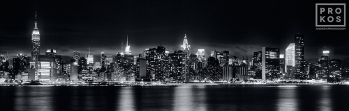 A panoramic long-exposure skyline of New York City at night in black and white.
