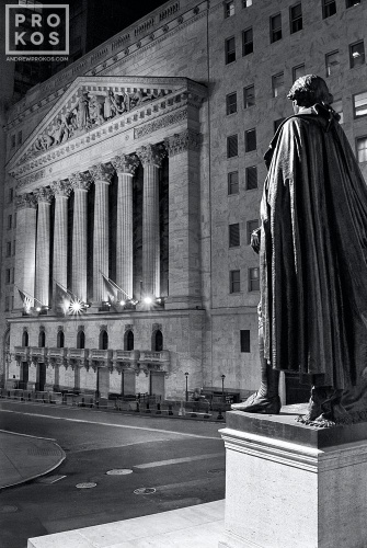 A fine art photo of the New York Stock Exchange (NYSE) and statue of George Washington at Federal Hall on Wall Street at night. Fine art prints of this photo are available framed in various styles. 