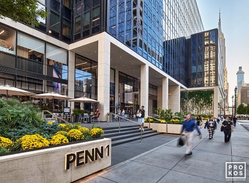 A street view of the exterior of Penn 1 tower with pedestrians, New York City, as seen during the day. Photographed by architectural photographer Andrew Prokos for Vornado Realty Trust. Fine art prints of this photo are available in various sizes.