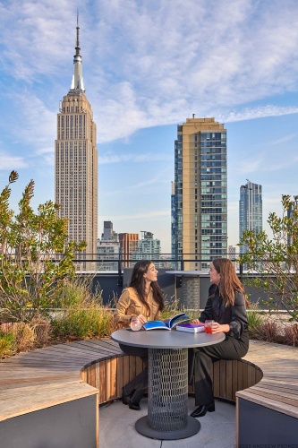 A view of people enjoying the Perch rooftop amenities at Penn 2, New York City. Photographed by architectural photographer Andrew Prokos for Vornado Realty Trust.