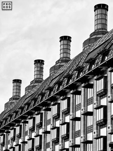 A black and white architectural photograph of the neo-gothic facade of Portcullis House, London, United Kingdom. Limited edition fine art prints of this photo are available up to 80 inches in height and framed in various wood, metal, and acrylic styles. 