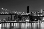 A black and white panoramic photo of the Queensboro Bridge and New York City skyline at night