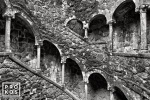 The Poco Iniciatico, a hidden well with arched spiral stairway in the Quinta da Regaleira gardens of Sintra, Portugal captured in black and white