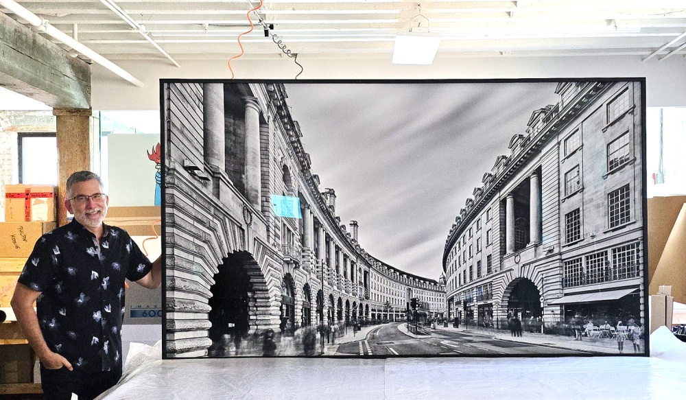 Photographer Andrew Prokos with a 96 Inch framed long-exposure photo of Regent Street in London.