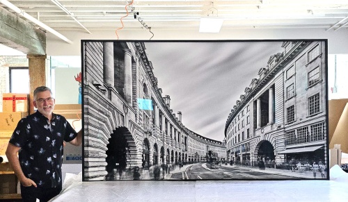 Photographer Andrew Prokos with a 96 Inch framed long-exposure photo of Regent Street in London.