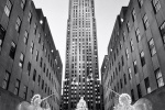 A black and white photograph of Rockefeller Center at Christmas with lighted angel decorations, New York City. Framed fine art prints of this photo are available in various styles.