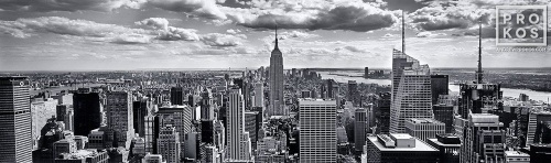 A black and white panoramic cityscape photo of New York City and the Empire State Building as seen from Rockefeller Center.