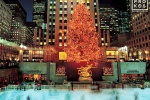 A long-exposure photo of the ice skaters under the lighted Christmas tree at Rockefeller Center, New York City