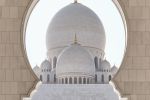 A fine art photo of the domes of Sheikh Zayed Grand Mosque framed by an Islamic arch, Abu Dhabi, UAE