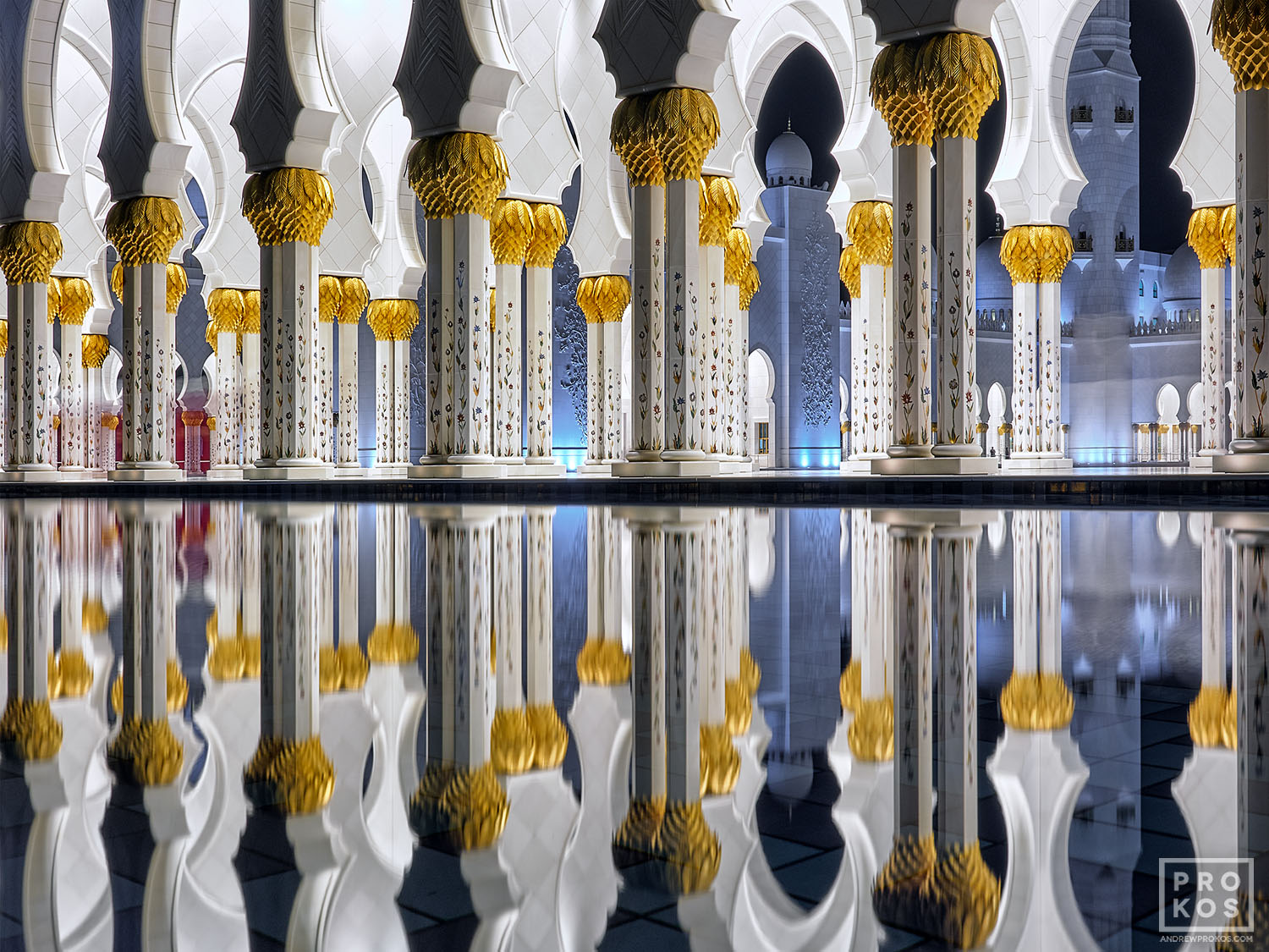 A view of the colonnade at Sheikh Zayed Grand Mosque at night, reflected in a pool. Abu Dhabi, United Arab Emirates. Limited edition fine art prints of this photo are available framed in various wood, metal, and acrylic styles. 