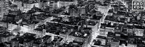 A panoramic fine art photo of the rooftops of Soho New York City at night in black and white.