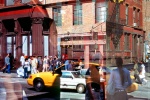 A street scene photo of the reflections of passersby in a Soho dress shop window, New York City